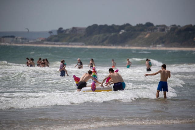 People enjoy the sunshine on the beach in Bournemouth, Dorset