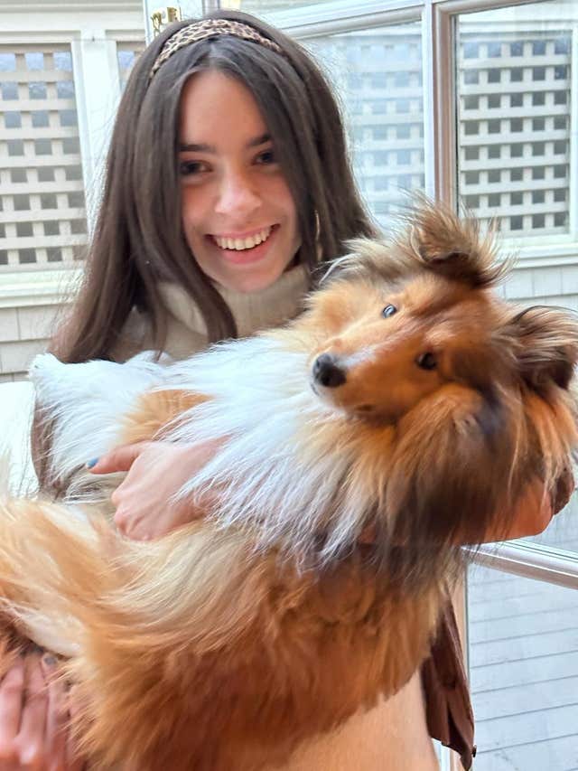 Hannah Lynch cuddling a collie dog