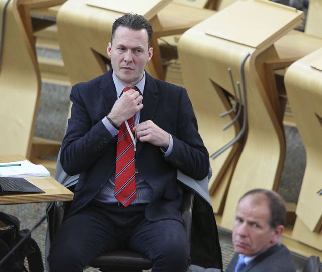 Russell Findlay adjusting his tie in the Holyrood chamber