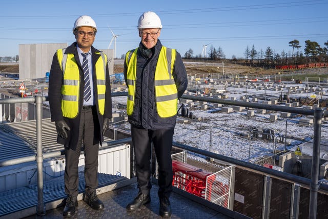 John Swinney and Nischal Agarwal in front of a battery storage facility