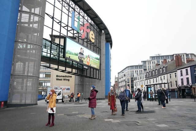 People queue outside the NHS vaccine centre that has been set up at the Centre for Life in Times Square, Newcastle (Owen Humphreys/PA)