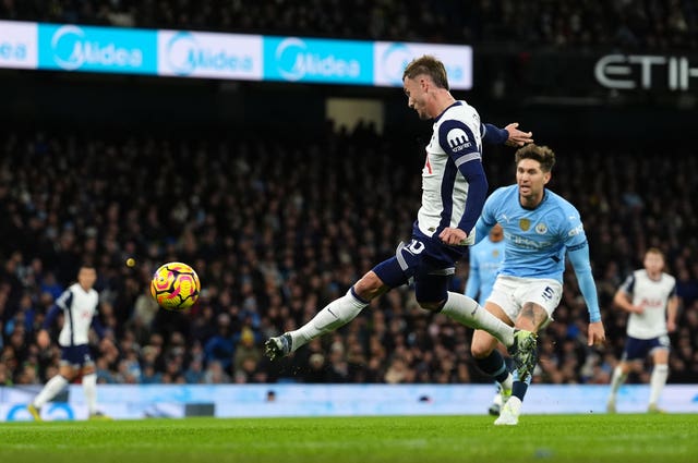 James Maddison volleys Tottenham in front as Manchester City defender John Stones looks on