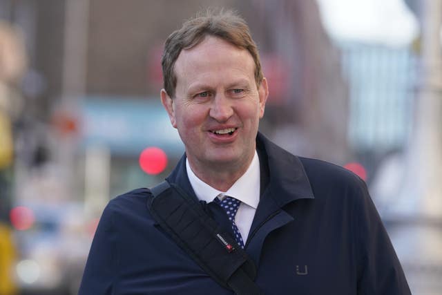 Jim O’Callaghan smiling while walking outside, dressed in jacket