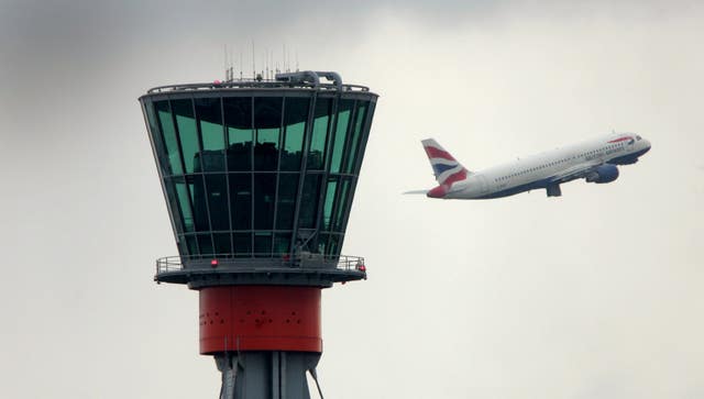A British Airways passes the control tower at Heathrow Airport (Tim Ockenden/PA)