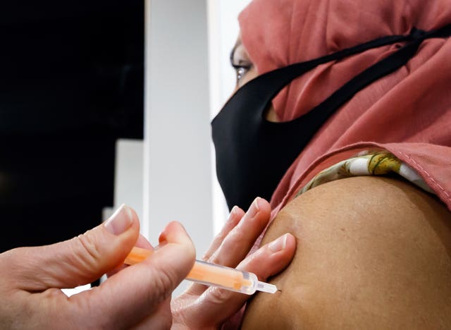 A woman receives an injection of the the Oxford/AstraZeneca coronavirus vaccine 