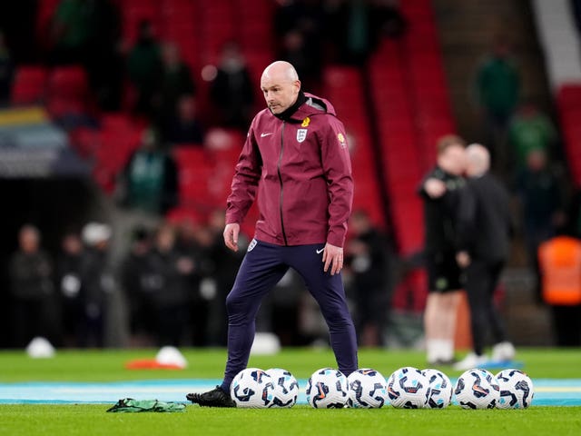 Lee Carsley during a warm-up next to a bunch of footballs