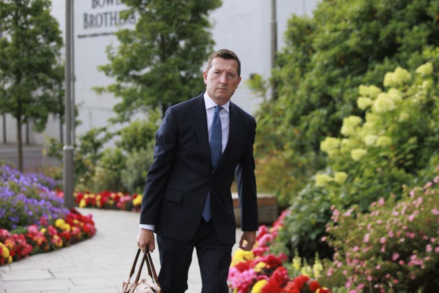 Paul Greaney KC walking outside, carrying a holdall