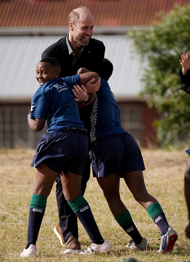 The Prince of Wales is tackled by two children