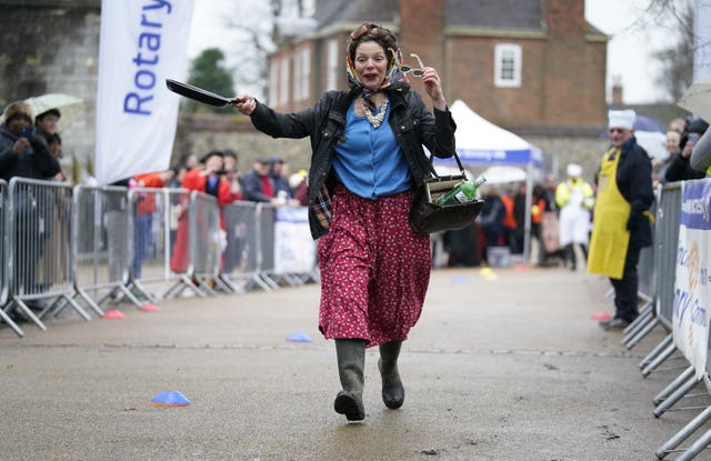 Runners in fancy dress take part in the Shrove Tuesday pancake race at Winchester Cathedral 