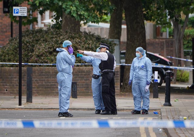 Police and forensic officers behind a police cordon
