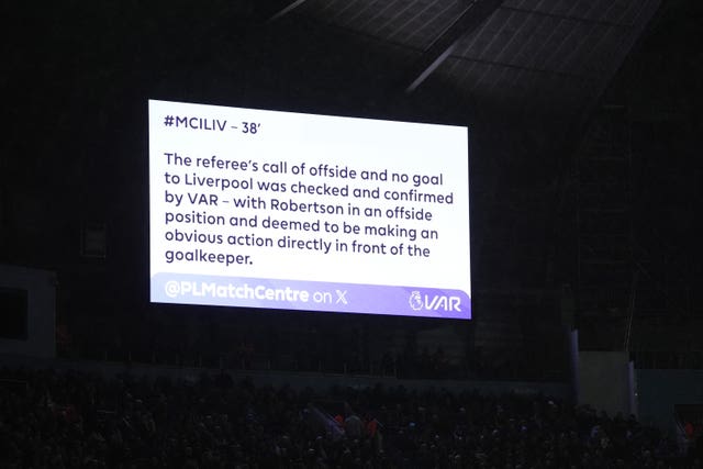 A TV screen displays a Premier League statement detailing why Liverpool's goal was offside