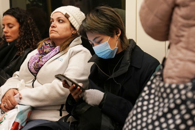 A woman wearing a face mask on the London Underground