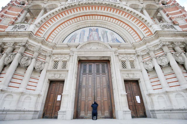 A woman praying at the closed doors of Westminster Cathedral 