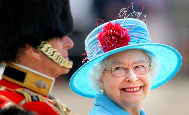 The Queen, in blue for a Trooping the Colour parade, smiling at the Duke of Edinburgh (Lewis Whyld/PA)