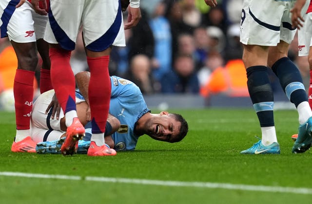 Manchester City midfielder Rodri lies injured on the ground clutching his leg during Sunday's game against Arsenal