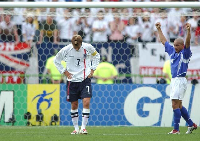 England captain David Beckham is dejected as Brazilian Roberto Carlos celebrates