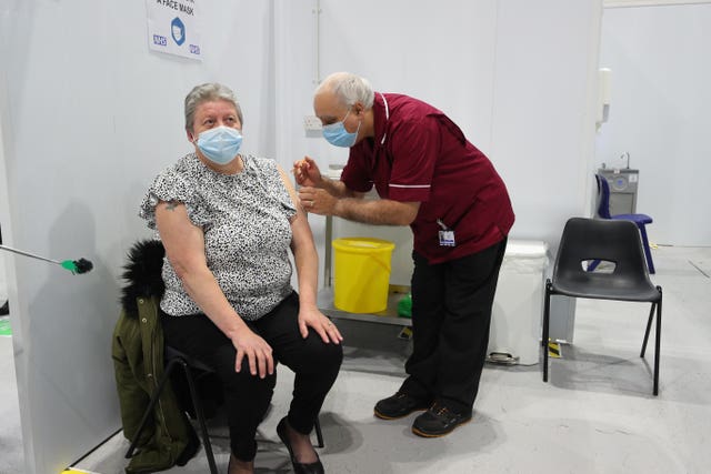 Robert Ward, 56, a retired nurse from Blackpool Victoria Hospital, injects Joanne McLaren, the first patient to receive a dose of the Oxford/Astrazeneca coronavirus vaccine during a clinic at the Winter Gardens (Peter Byrne/PA)