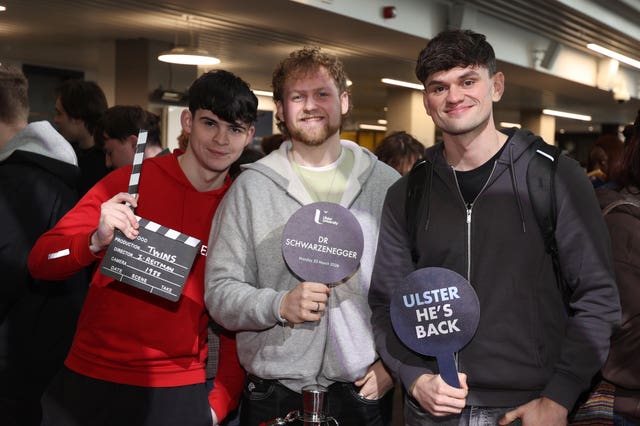 Arnold Schwarzenegger fans hold plaques ahead of a ceremony presenting him with an honorary doctorate at Ulster University in Belfast