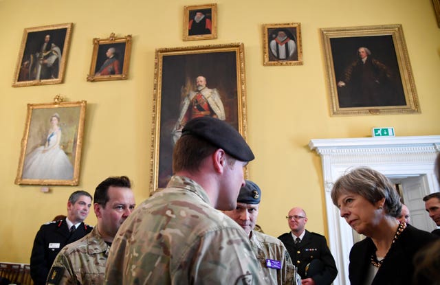 Theresa May met members of the emergency services on her visit to Salisbury to view the area of the suspected nerve agent attack (Toby Melville/PA)