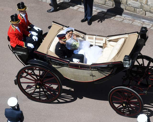 The Duke and Duchess of Sussex ride in an open-topped carriage through Windsor Castle (Victoria Jones/PA)