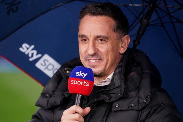 Football pundit Gary Neville standing under an umbrella with a microphone