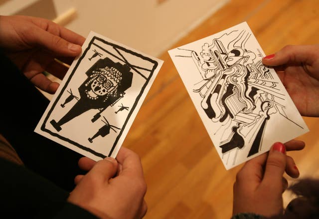 Hands holding drawings by artists Derek Boshier and Dan Stewart 