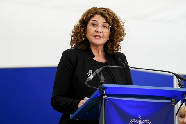 Dame Diana Johnson, wearing a dark suit, standing at a lectern