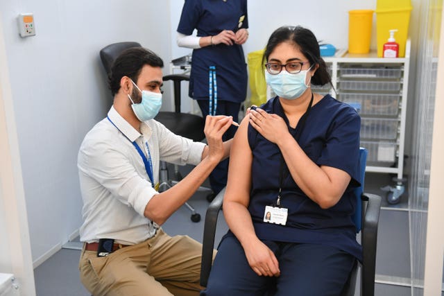 Principal Pharmacist Davinder Manku (right) receives an injection of the Oxford/Astrazeneca coronavirus vaccine at The Black Country Living Museum in Dudley which has previously been used as a set for the BBC drama Peaky Blinders