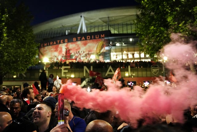 Arsenal fans celebrate with flares outside the Emirates Stadium