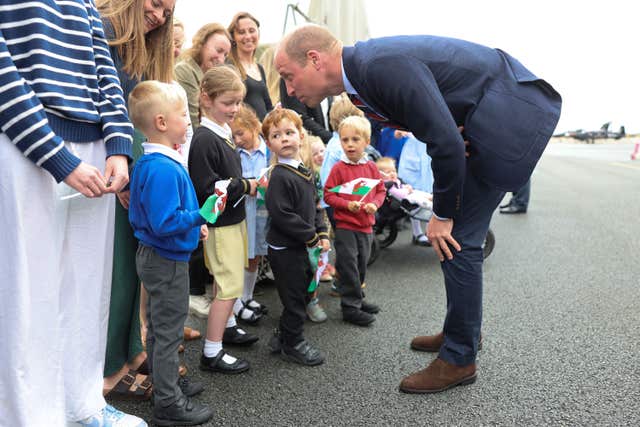 William talks with children holding Welsh flags