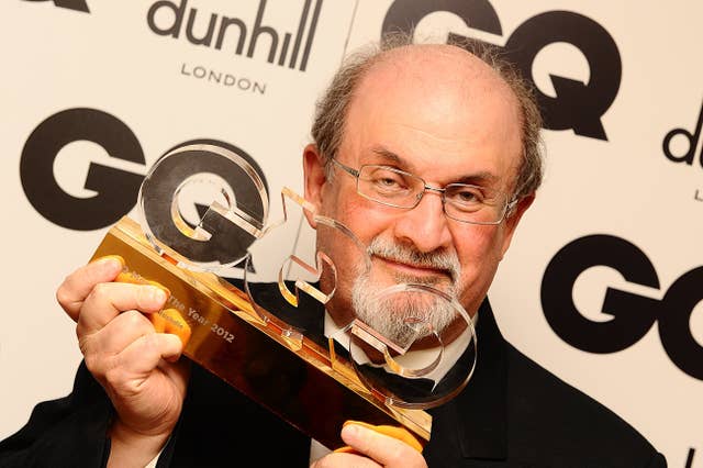 Sir Salman Rushdie holding up his GQ Man of the Year award