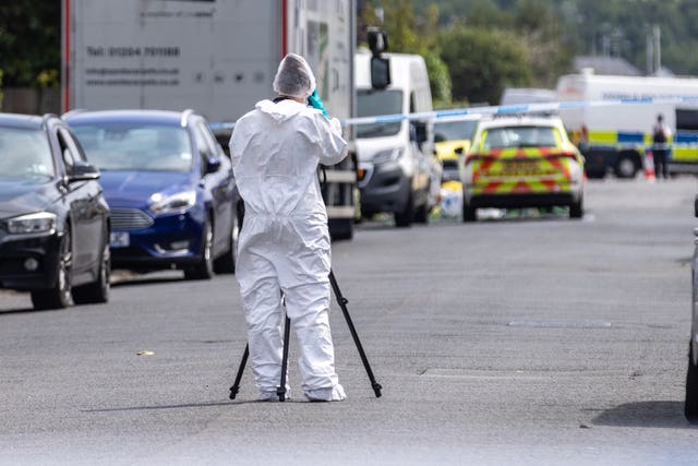 A forensic investigator at work in a street