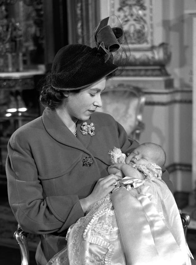 Princess Elizabeth gazes at her first born Prince Charles as she holds him in her arms after his christening in 1948