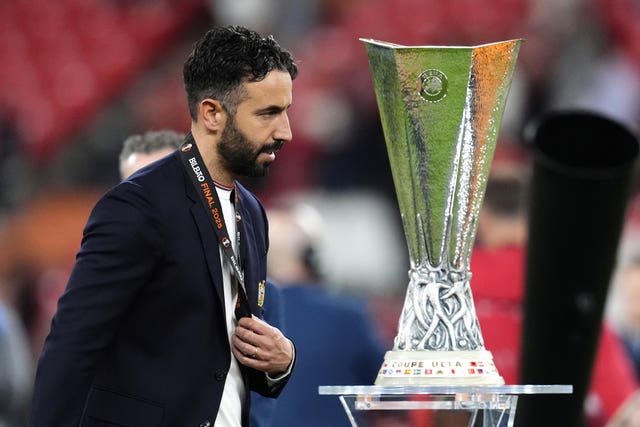 Manchester United manager Ruben Amorim walks past the trophy 