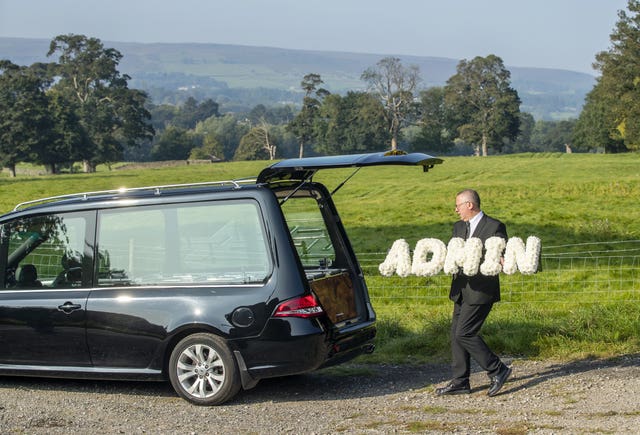 Funeral director Tim Twigger from Full Circle Funerals, with a floral tribute that reads “Admin”, at Weston Church in Otley, West Yorkshire (Danny Lawson/PA)