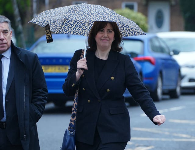 Lucy Powell walking with an umbrella