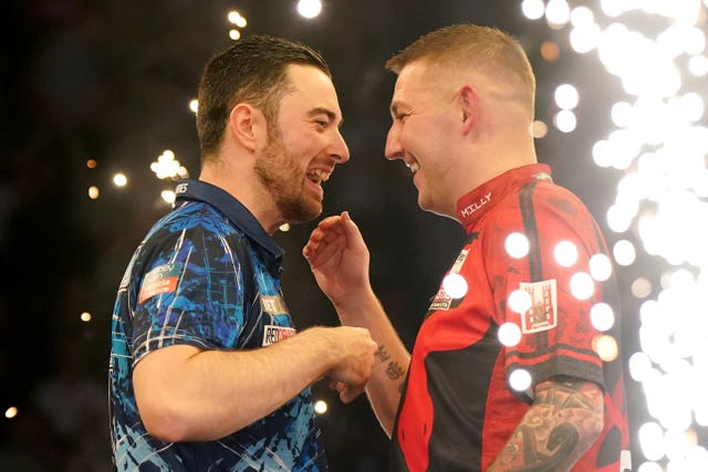 Luke Humphries (left) celebrates victory over Nathan Aspinall (right)