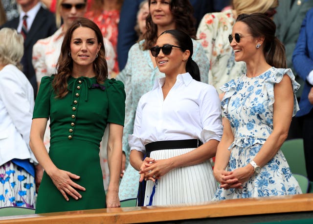 The then-Duchess of Cambridge, Meghan and Kate's sister Pippa Matthews stand in the royal box at Wimbledon