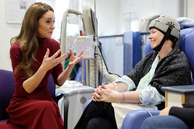 Kate gesturing as she chats to patient Katherine Field who is wearing a cold cap while having chemotherapy