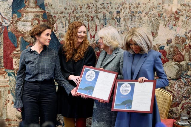 Two young women with the Queen and Brigitte Macron