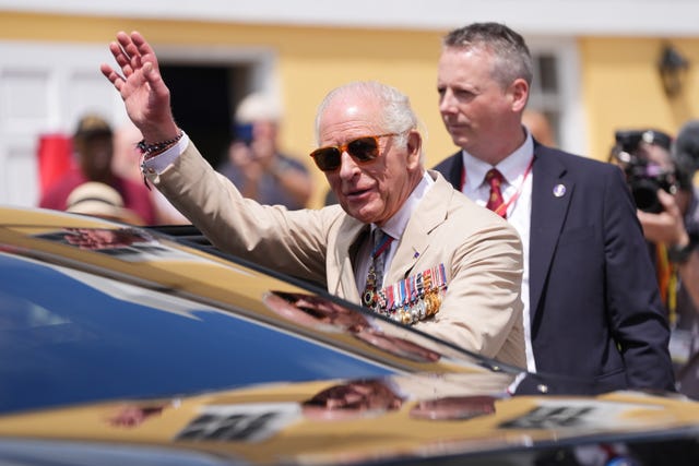 The King waves to well-wishers during a ceremonial welcome