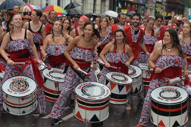 Participants take part in a rainswept Notting Hill Carnival in 2014 (John Stillwell/PA)