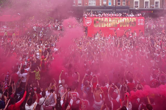 Crowds of supporters celebrating as the bus drives through north London