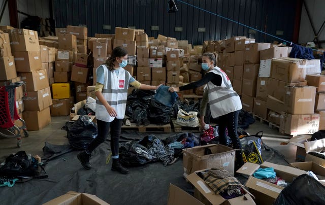 Volunteers go through donated clothes at the Care4Calais warehouse 