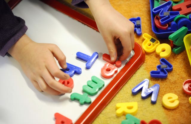 Close-up of child's hands playing with letters 