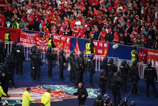 Police stand in front of Liverpool fans during the Champions League final at the Stade de France