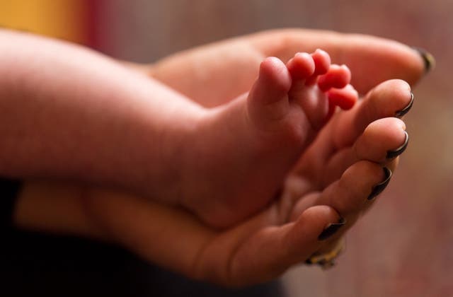 A mother holds a baby's foot