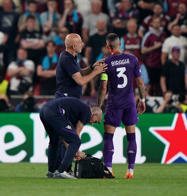 Fiorentina’s Cristiano Biraghi receives treatment for a cut to the head after being struck by an object thrown during the Europa Conference League final 