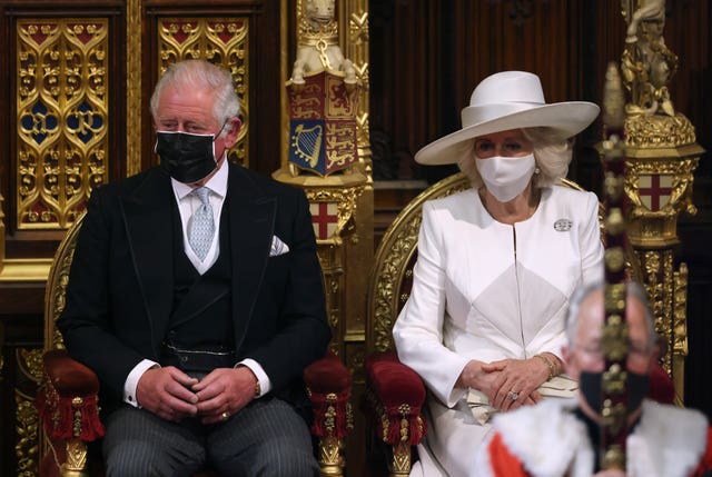 The Prince of Wales and the Duchess of Cornwall listen as the Queen delivers the speech