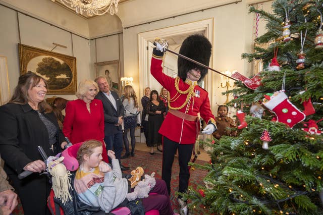 The Queen Consort, accompanied by children supported by Helen and Douglas House and Roald Dahl’s Marvellous Children’s Charity, decorate the Christmas tree at Clarence House in London
